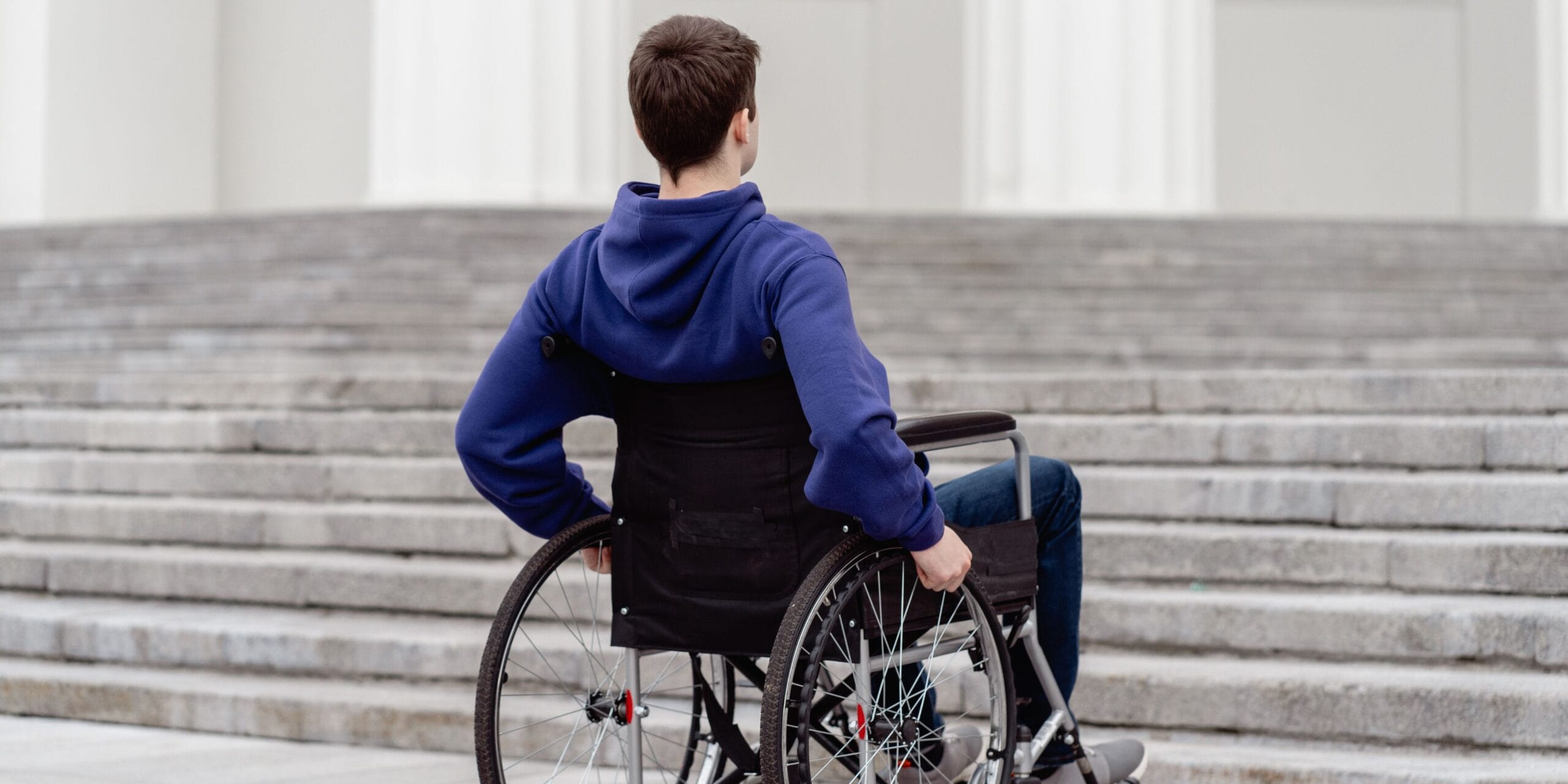 Wheelchair user at the bottom of a set of steps