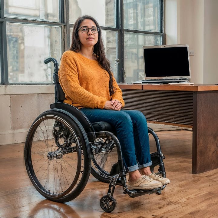 Woman in a wheelchair working at her desk at home